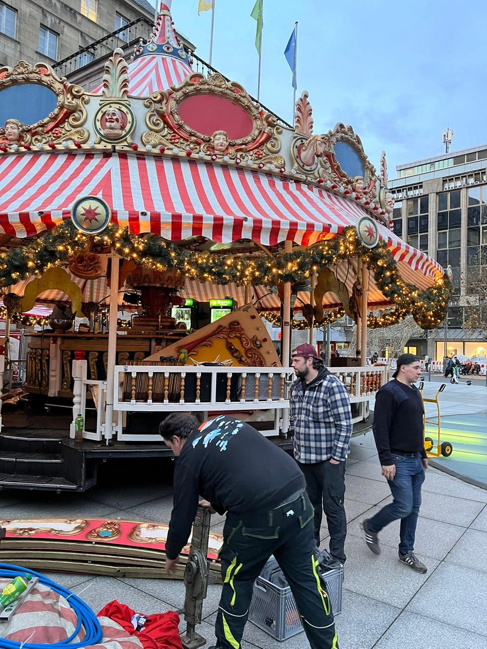 Drei Mitarbeiter beim Aufbau des Karussells auf dem Platz